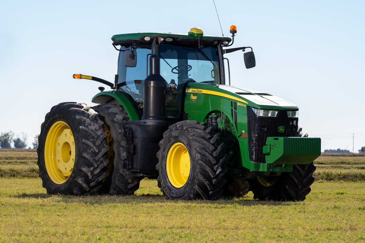 John Deere tractor parked on a flat Imperial Valley field under a clear sky near Brawley, California.